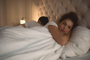 感じにくいことに悩みながら横になる女性の様子