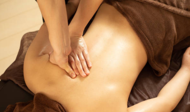 背中のオイルマッサージを受けてリラックスする女性