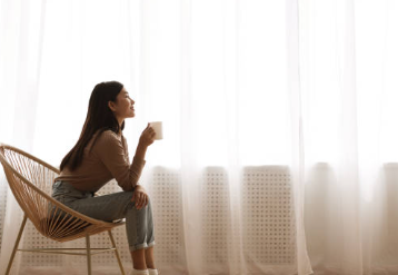 窓際でお茶を飲みながら女性用風俗について考える女性