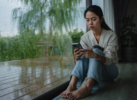 スマートフォンで感じにくい原因を調べている女性